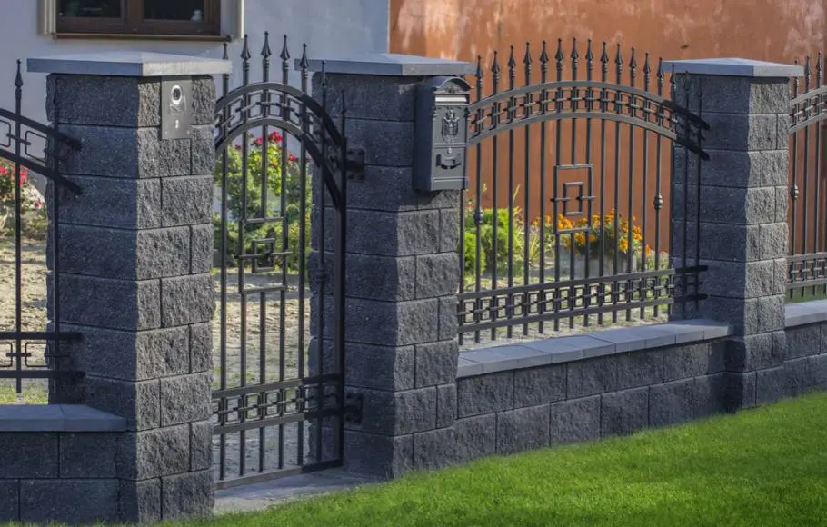 Metal and concrete fencing surrounding a home, welded and built by Navarro Metalworks
