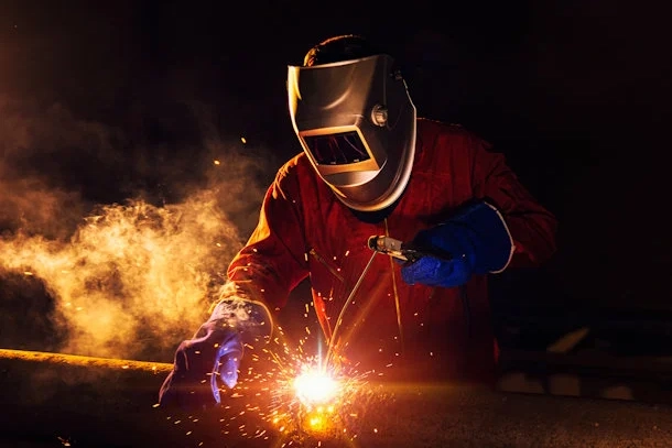 Navarro Metalworks employee welding a steel beam